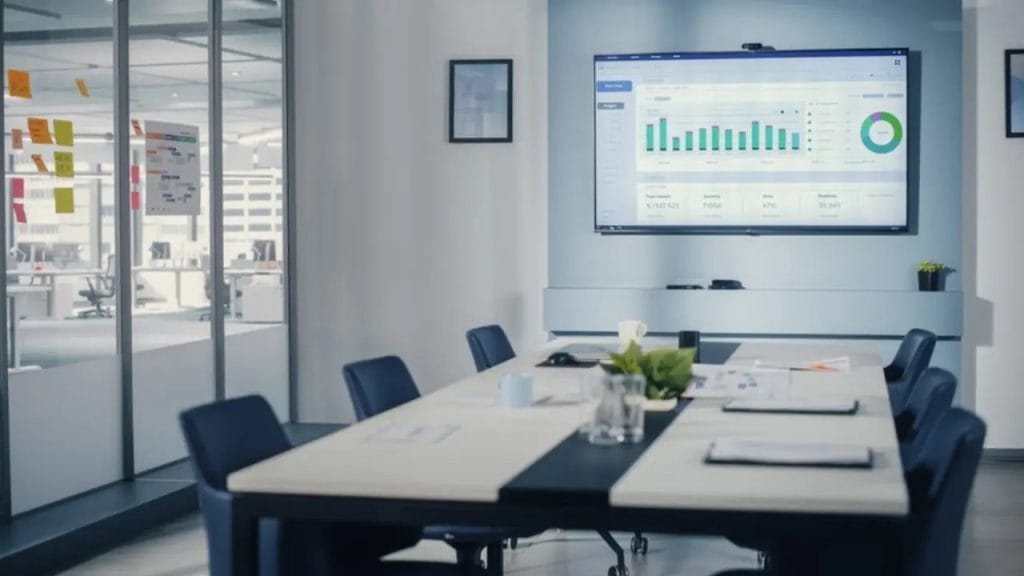 غرفة اجتماعات تحتوي على مكتب وشاشة توضح رسم بياني